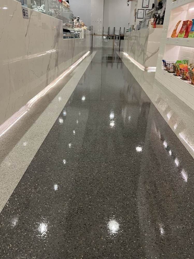 Clean, glossy concrete floor down a long aisle